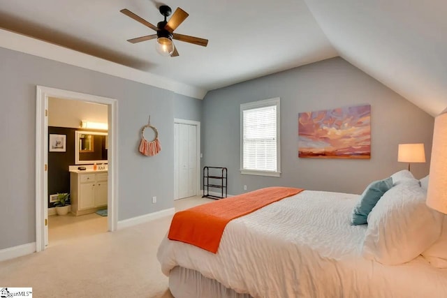 bedroom featuring light colored carpet, ensuite bath, a ceiling fan, baseboards, and lofted ceiling