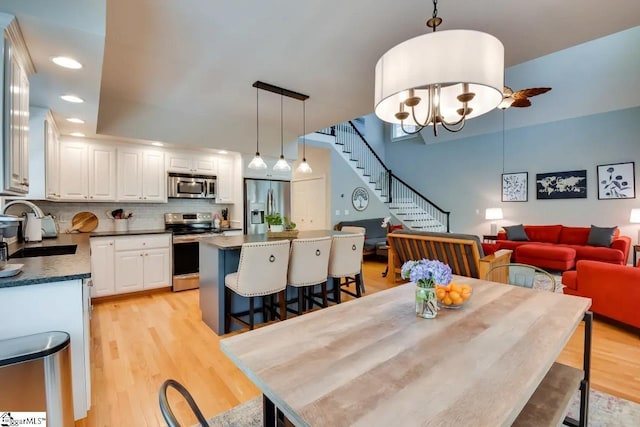 dining space with recessed lighting, a chandelier, stairway, and light wood-type flooring