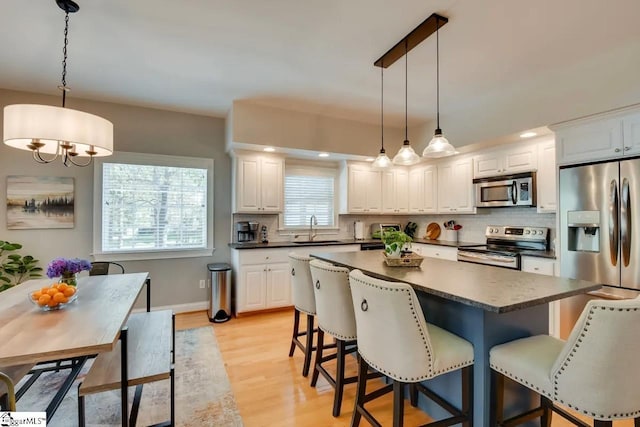 kitchen featuring a sink, dark countertops, decorative backsplash, and stainless steel appliances