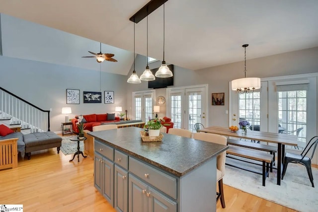 kitchen featuring plenty of natural light, open floor plan, light wood finished floors, and dark countertops