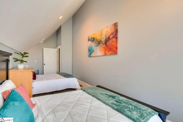 bedroom with baseboards and lofted ceiling