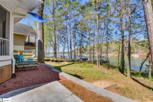 view of yard with a water view and fence