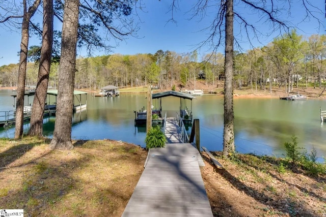 view of dock featuring a water view and a forest view
