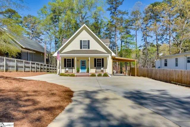 view of front of home featuring a carport, fence, driveway, and covered porch