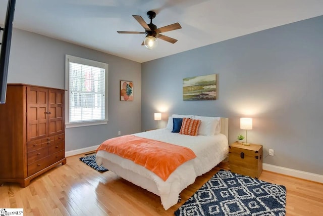 bedroom featuring a ceiling fan, baseboards, and wood finished floors