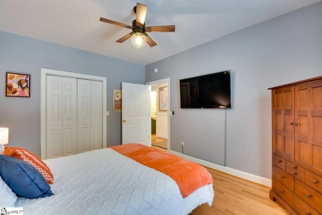 bedroom featuring baseboards, ceiling fan, a closet, and light wood-style flooring