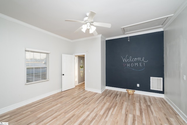 unfurnished room featuring visible vents, crown molding, wood finished floors, attic access, and ceiling fan