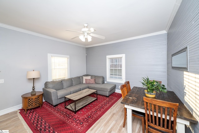 living area with crown molding, ceiling fan, a wealth of natural light, and light wood finished floors