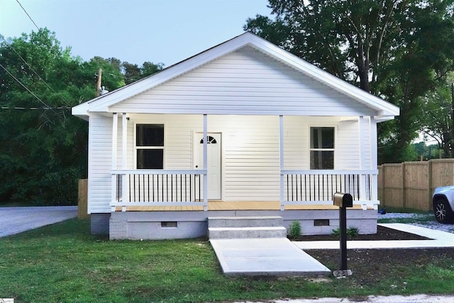 view of front of property featuring fence, covered porch, and crawl space