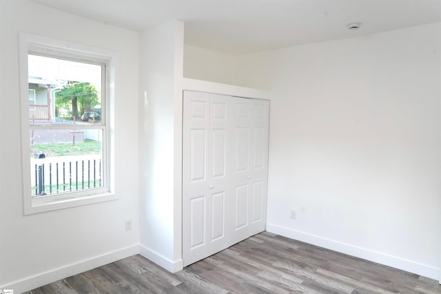 unfurnished bedroom with baseboards, a closet, and wood finished floors