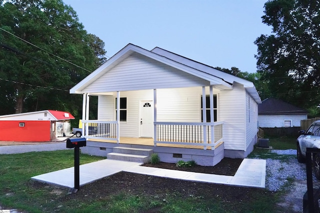 bungalow-style home with a porch, crawl space, central AC unit, and a front yard