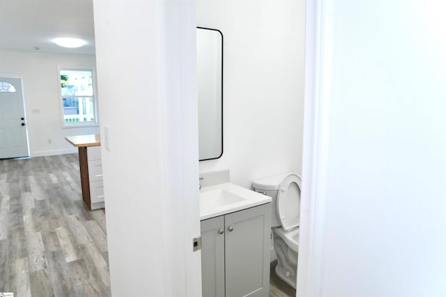 bathroom featuring toilet, wood finished floors, and vanity