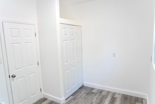 interior space featuring baseboards, a closet, and wood finished floors