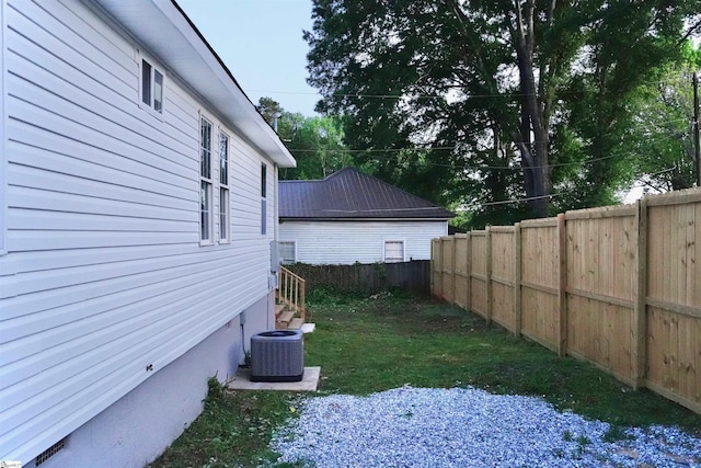 view of yard featuring central air condition unit and fence