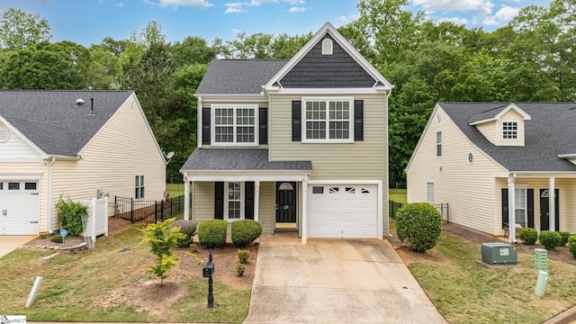 traditional-style home featuring a front yard, fence, covered porch, and driveway