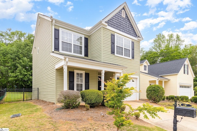 traditional home featuring a front lawn, an attached garage, fence, concrete driveway, and a porch