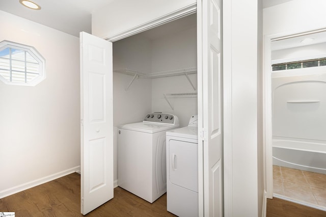 washroom with washer and dryer, laundry area, and wood finished floors