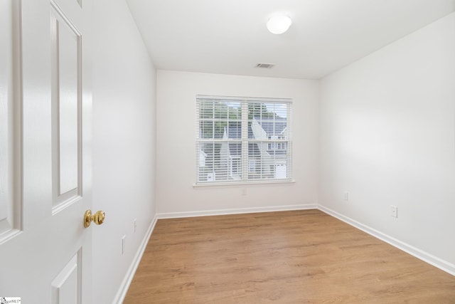 unfurnished room featuring baseboards, visible vents, and light wood-type flooring