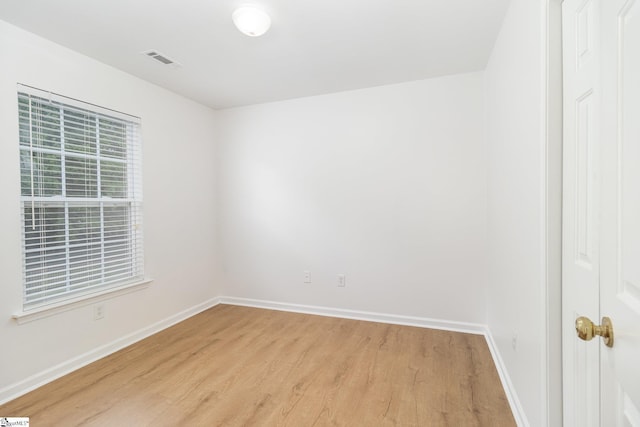 unfurnished room featuring baseboards, visible vents, and light wood-style flooring