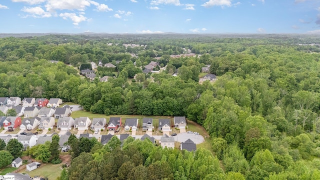 birds eye view of property featuring a residential view and a wooded view