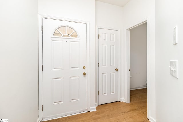 entryway with baseboards and light wood finished floors