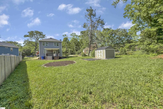 view of yard featuring fence, an outbuilding, and a storage unit