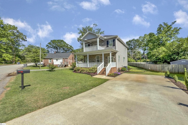 view of front of home featuring fence, a front lawn, a porch, a balcony, and driveway