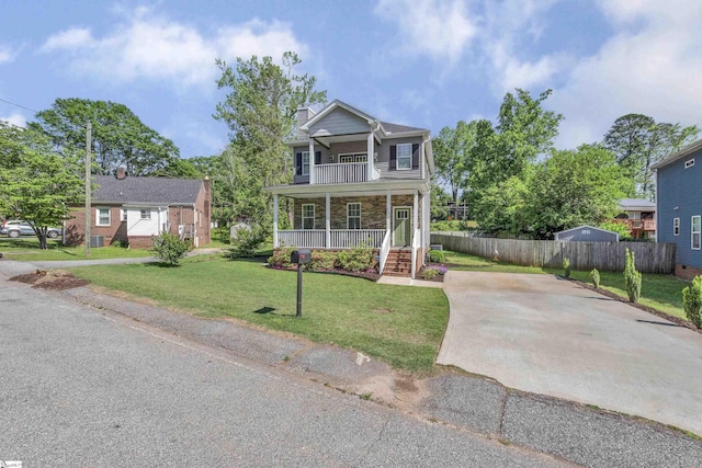 view of front of home featuring fence, stone siding, a porch, a front yard, and driveway
