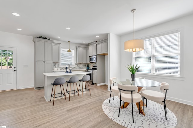 dining area featuring light wood-style floors, recessed lighting, baseboards, and a wealth of natural light