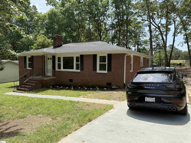 view of front facade featuring brick siding, crawl space, a chimney, and a front yard