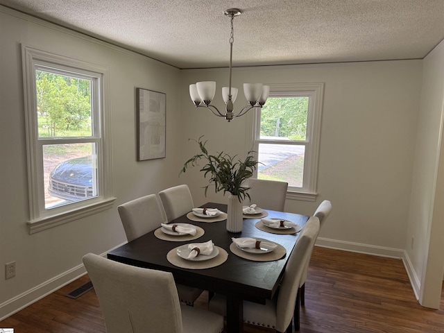 dining room featuring an inviting chandelier, a textured ceiling, baseboards, visible vents, and dark wood-style floors