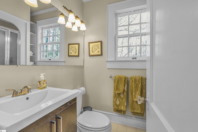bathroom featuring crown molding, a shower with shower door, vanity, toilet, and an inviting chandelier