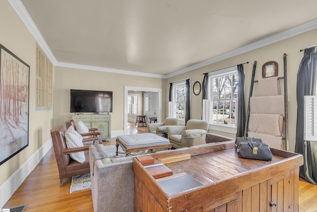 living room featuring light wood-style floors, baseboards, and crown molding