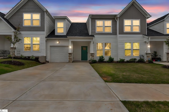 view of front of property featuring a lawn, driveway, board and batten siding, and a garage