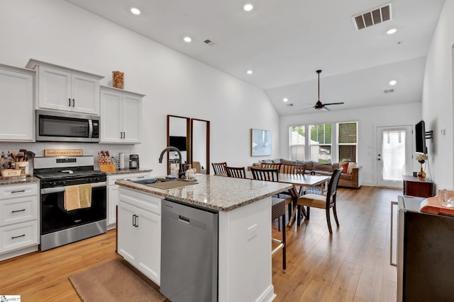 kitchen with visible vents, a ceiling fan, an island with sink, a sink, and appliances with stainless steel finishes