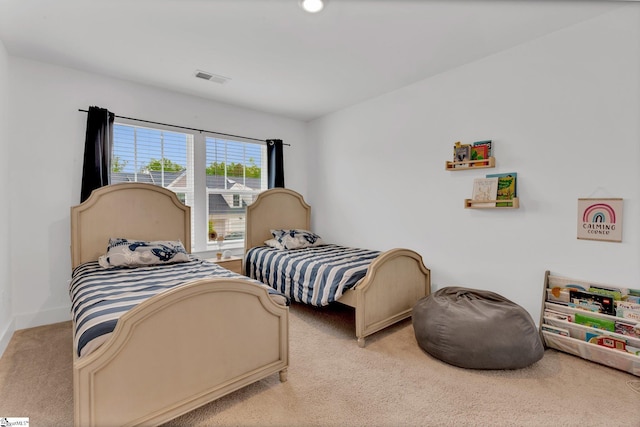 bedroom featuring baseboards, light carpet, and visible vents
