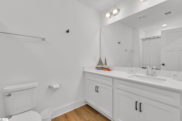 full bath featuring toilet, baseboards, visible vents, and wood finished floors