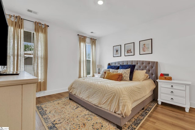 bedroom with light wood-style floors, baseboards, and visible vents