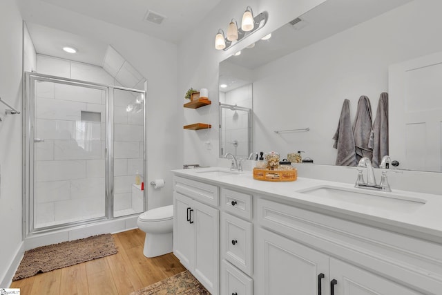 full bath with visible vents, a sink, wood finished floors, and toilet