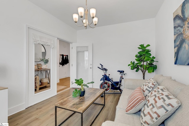 living room with baseboards, wood finished floors, and a chandelier
