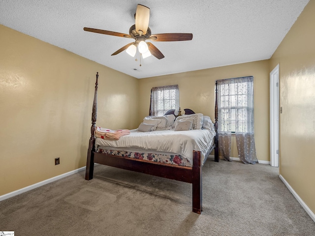 carpeted bedroom featuring baseboards, a textured ceiling, and ceiling fan