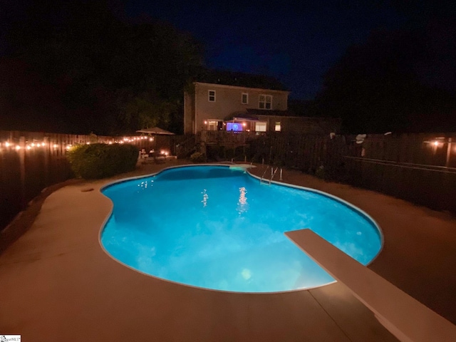 pool at twilight featuring a fenced in pool, a fenced backyard, and a patio