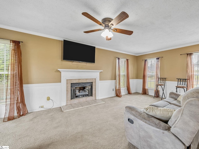 living room featuring a textured ceiling, ceiling fan, and a wainscoted wall