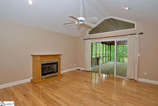 unfurnished living room with a ceiling fan, a textured ceiling, vaulted ceiling, and wood finished floors