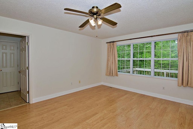 unfurnished room featuring baseboards, a textured ceiling, ceiling fan, and wood finished floors