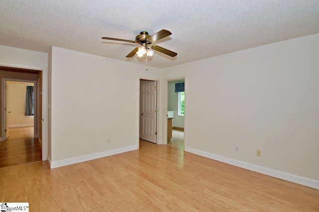 unfurnished room featuring a textured ceiling, baseboards, a ceiling fan, and light wood-style flooring