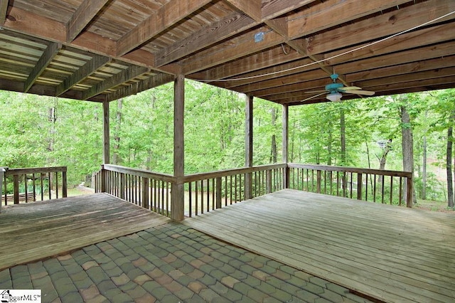 deck with a forest view and ceiling fan