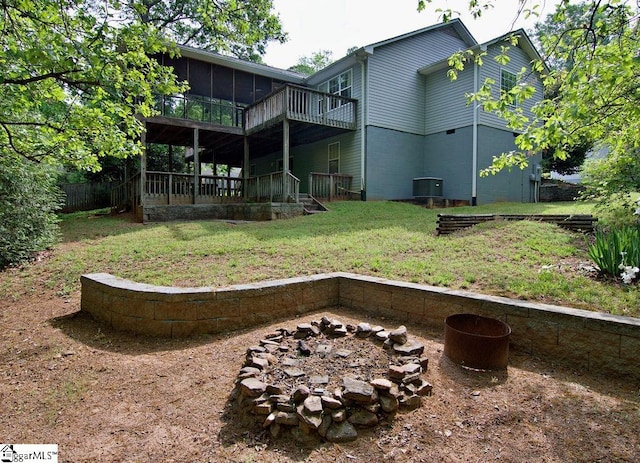 view of yard featuring a wooden deck, a sunroom, a fire pit, and central AC