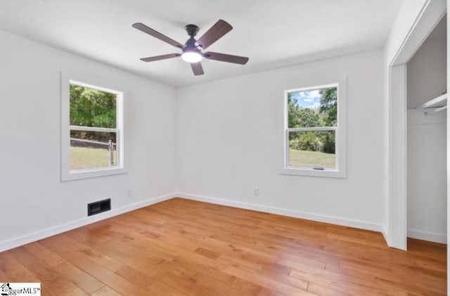 unfurnished bedroom featuring light wood-style floors, a ceiling fan, baseboards, visible vents, and a closet