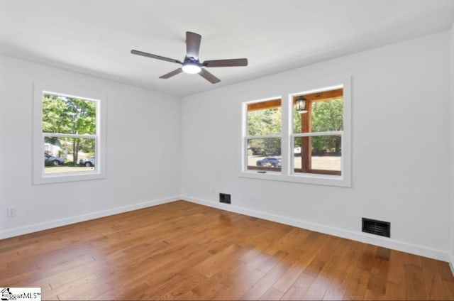 empty room with visible vents, baseboards, a wealth of natural light, and light wood-type flooring